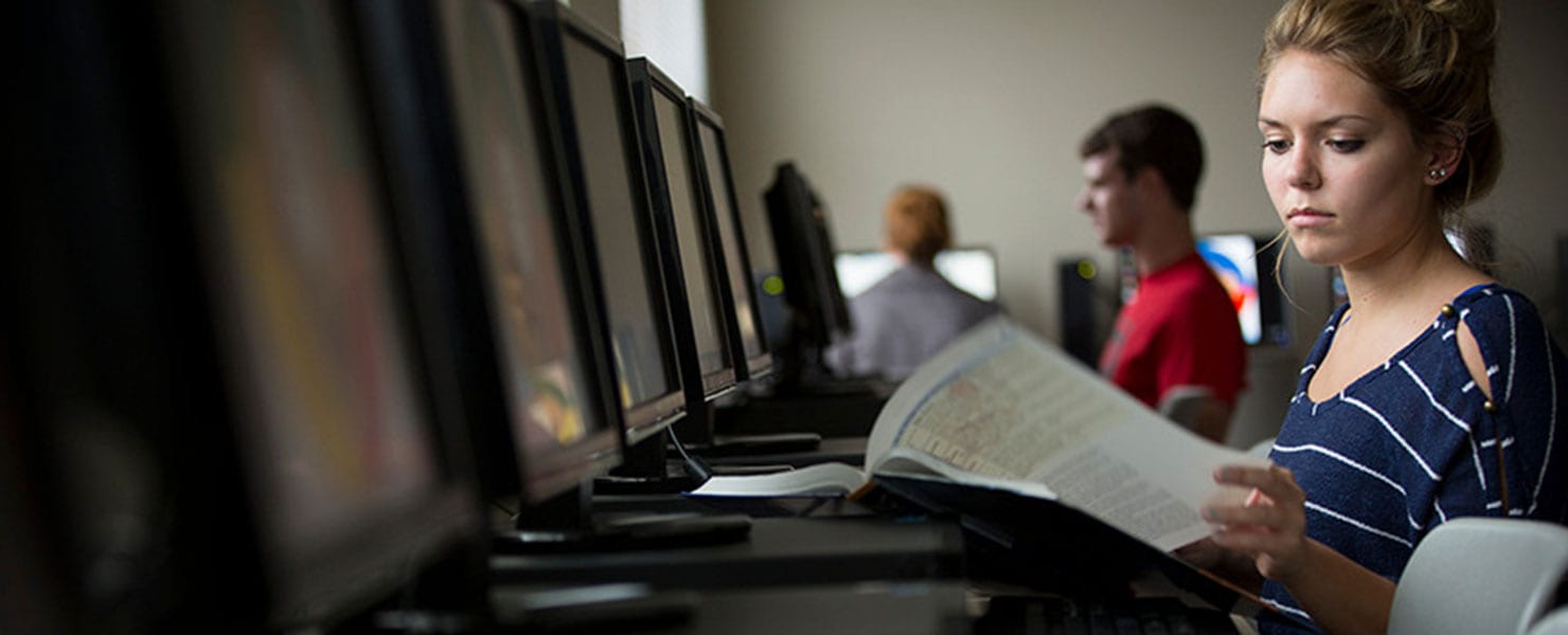 MU student in classroom setting working at a computer.