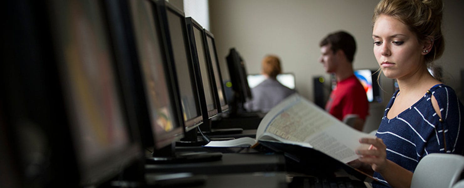 MU student in classroom setting working at a computer.