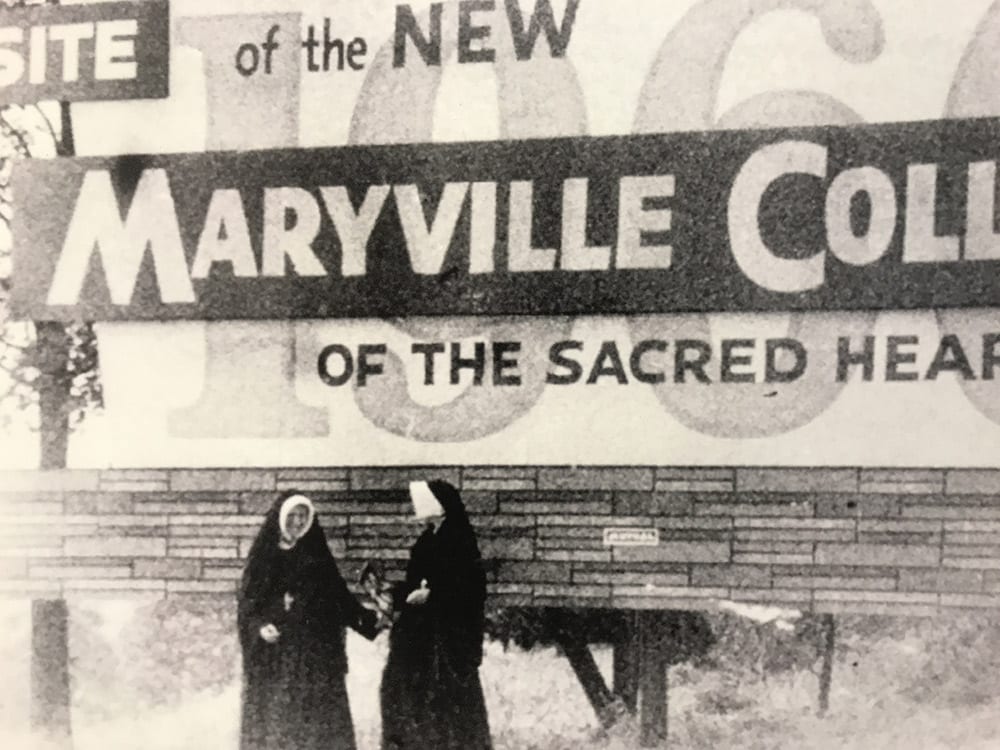 Two Sisters standing in front of sign