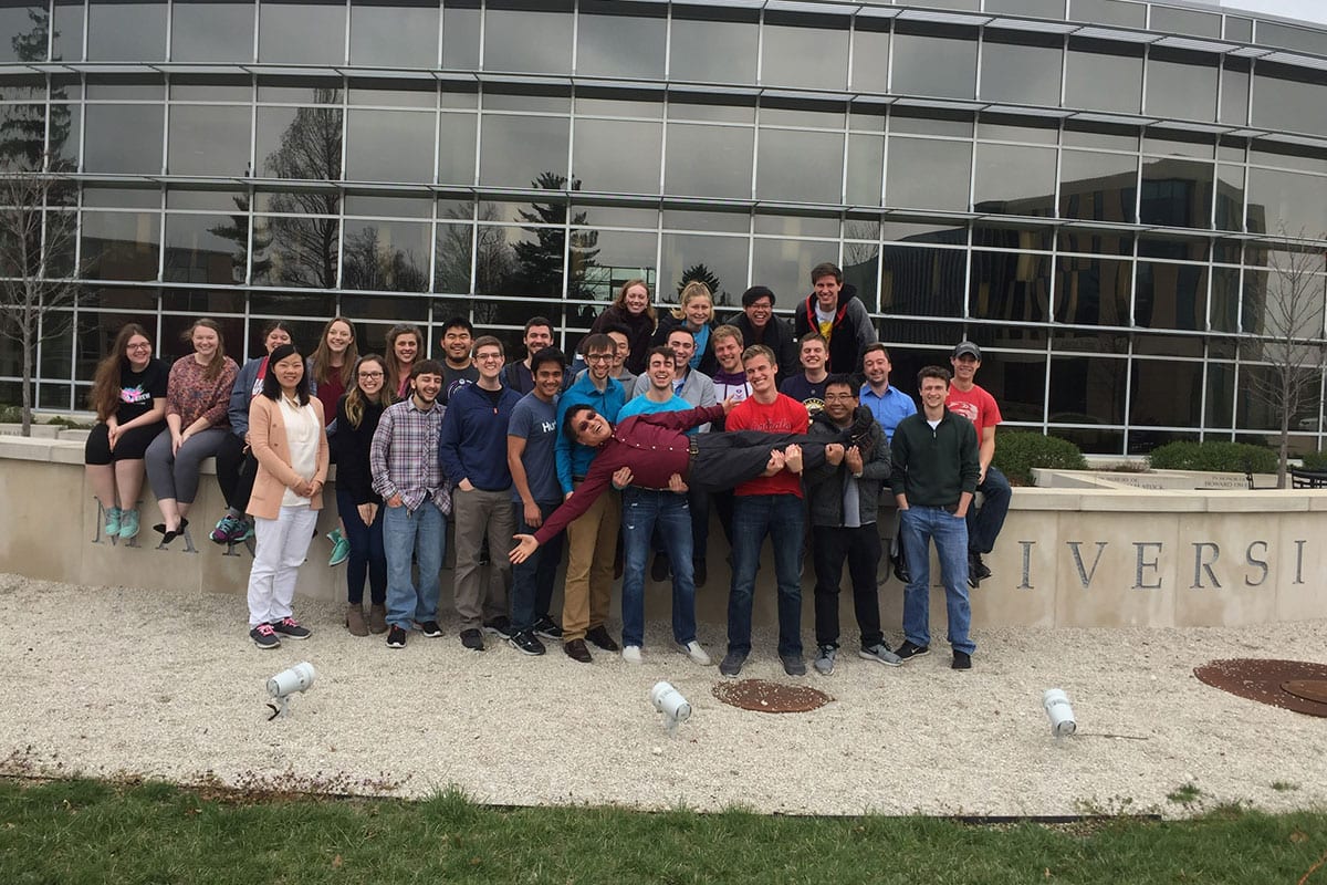 Actuarial Science program director Guangwei Fan with students in front of Gander Hall