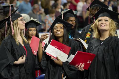 graduates holding up diplomas
