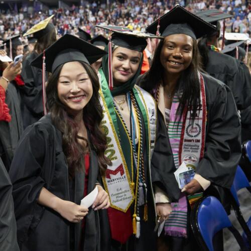 three happy graduates smiling for camera