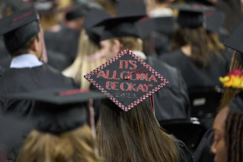 student with It's gonna be ok on mortar board