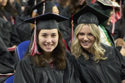 two female students smiling during ceremony