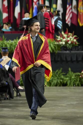 student walks back to his seat after receiving diploma
