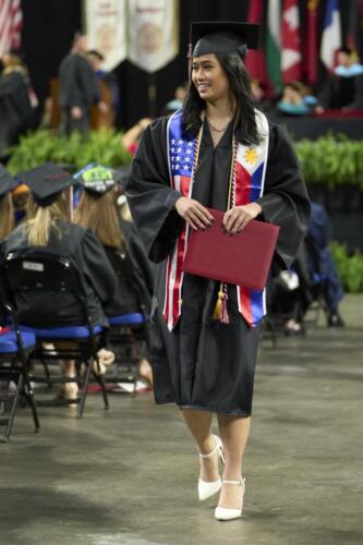 recent graduate smiling while walking down aisle
