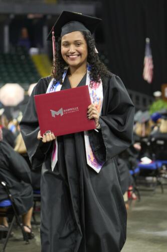 student walking back to seat after being handed diploma