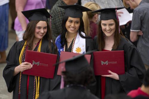 three graduates pose for photo after commencement
