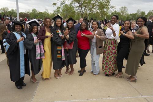 group of friends and family pose for picture with graduate