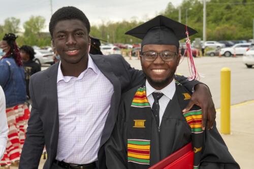 graduate posing with someone special to him after commencement