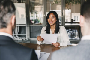 student handing resume over to business leaders