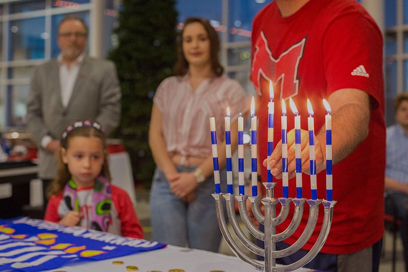 Maryville Hillel student lighting a candle during Hanukkah