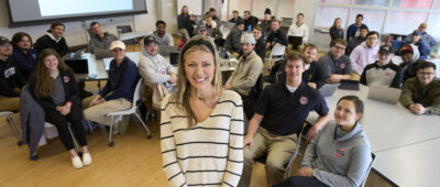 Lindsey Naber stands in front of Rawlings Sports Business Management class.