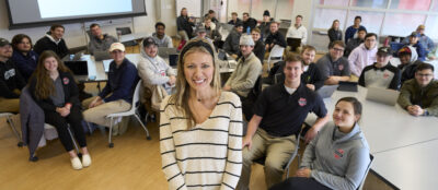 Lindsey Naber stands in front of Rawlings Sports Business Management class.
