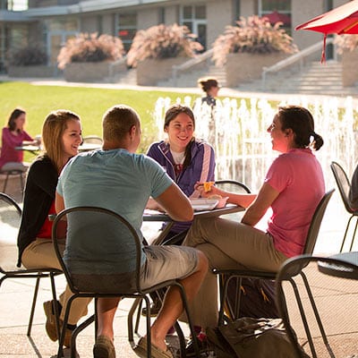 students sitting outside by fountain