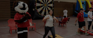 Louie and students play bean bag toss during Family Weekend