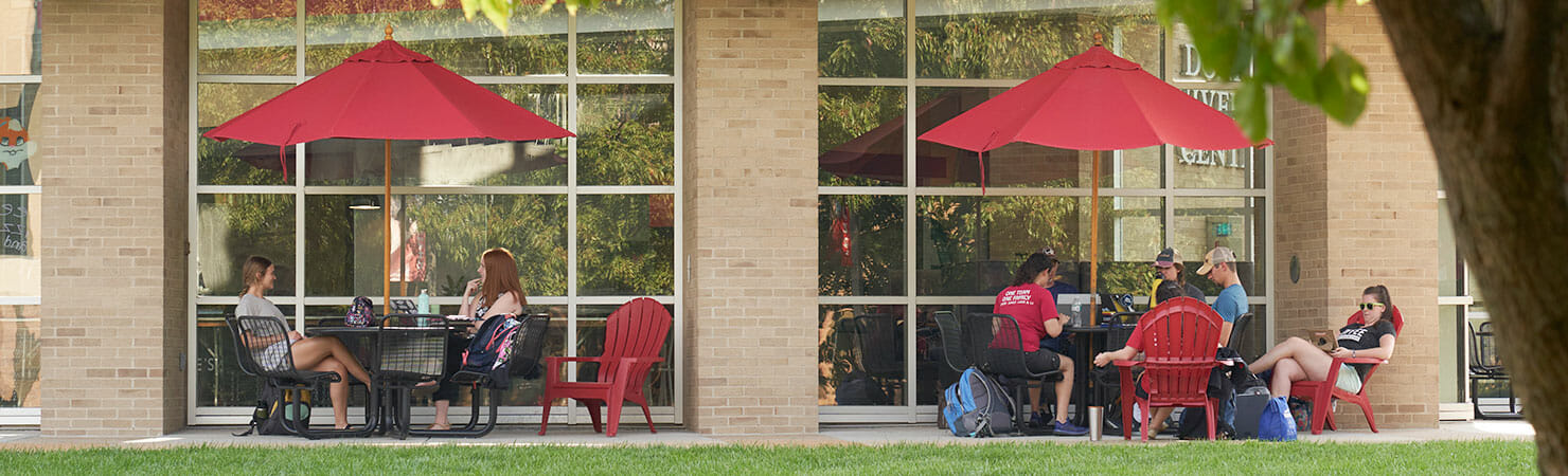 students lounging in front of Gander Hall