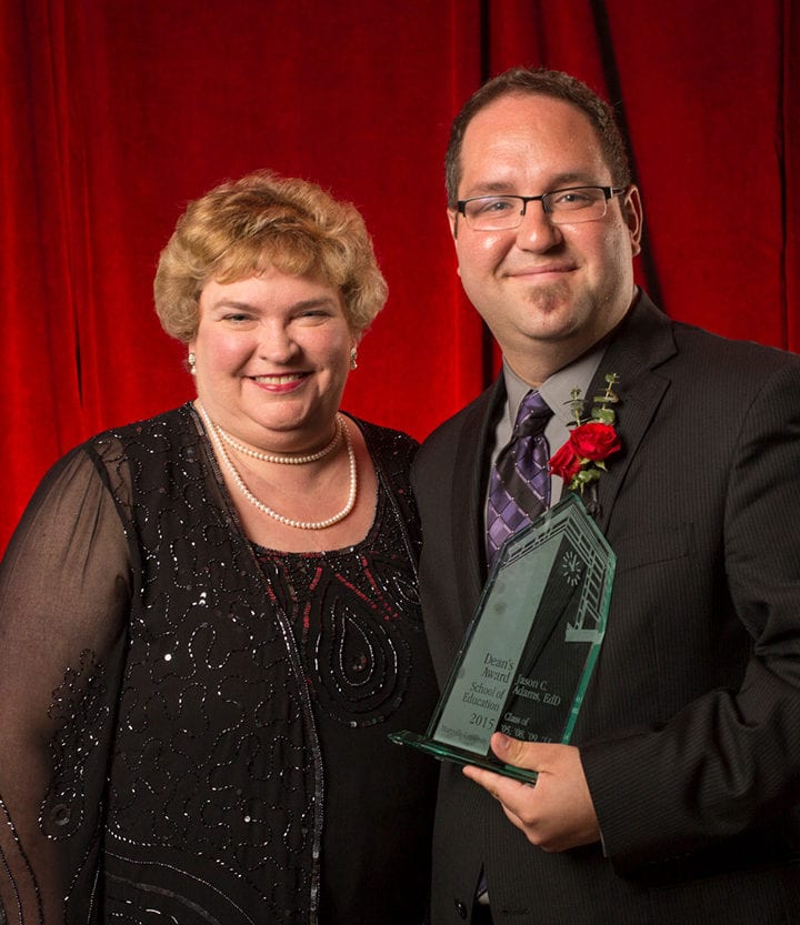 Jason Adams accepting Spirit of Maryville Award from faculty member