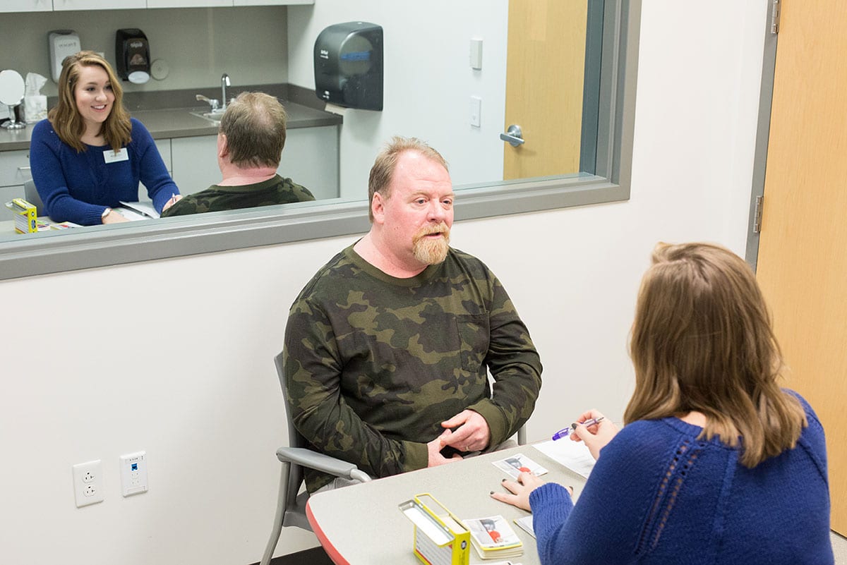 speech language pathologist sitting with client