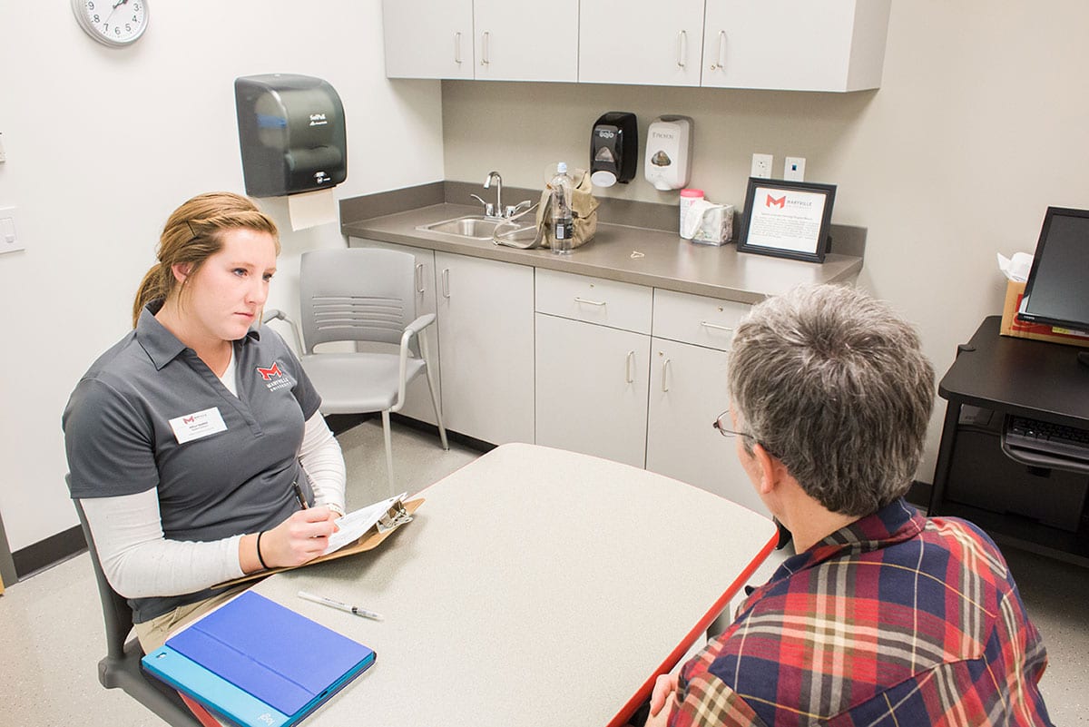Speech language pathologist sitting with client