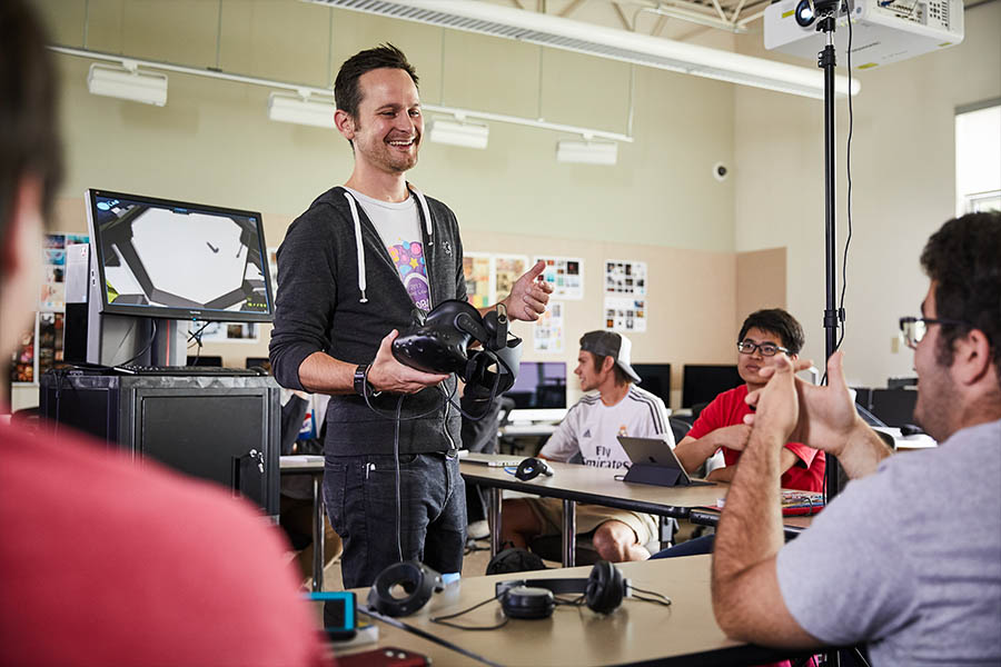 Teacher holding VR headset talking to students