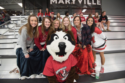 Louie with students watching ice hockey game